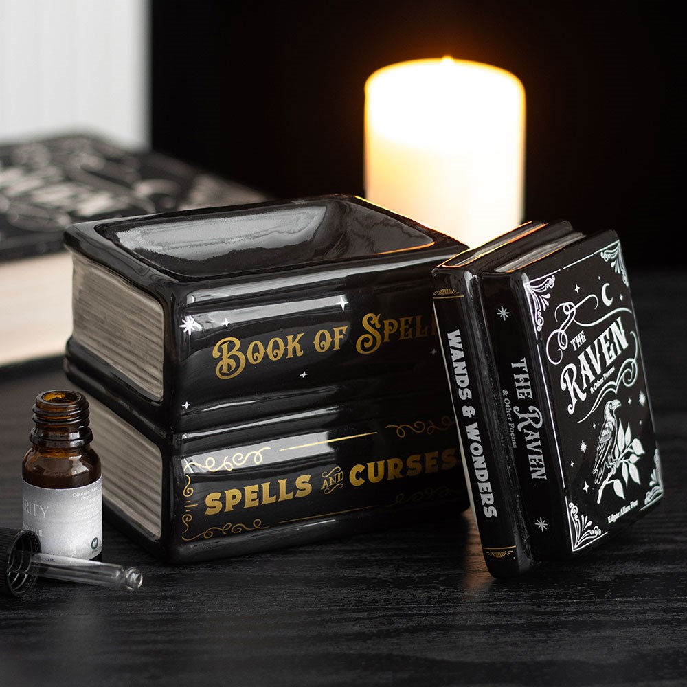 quemador de wax melts con forma de libros de hechizos apilados abierto